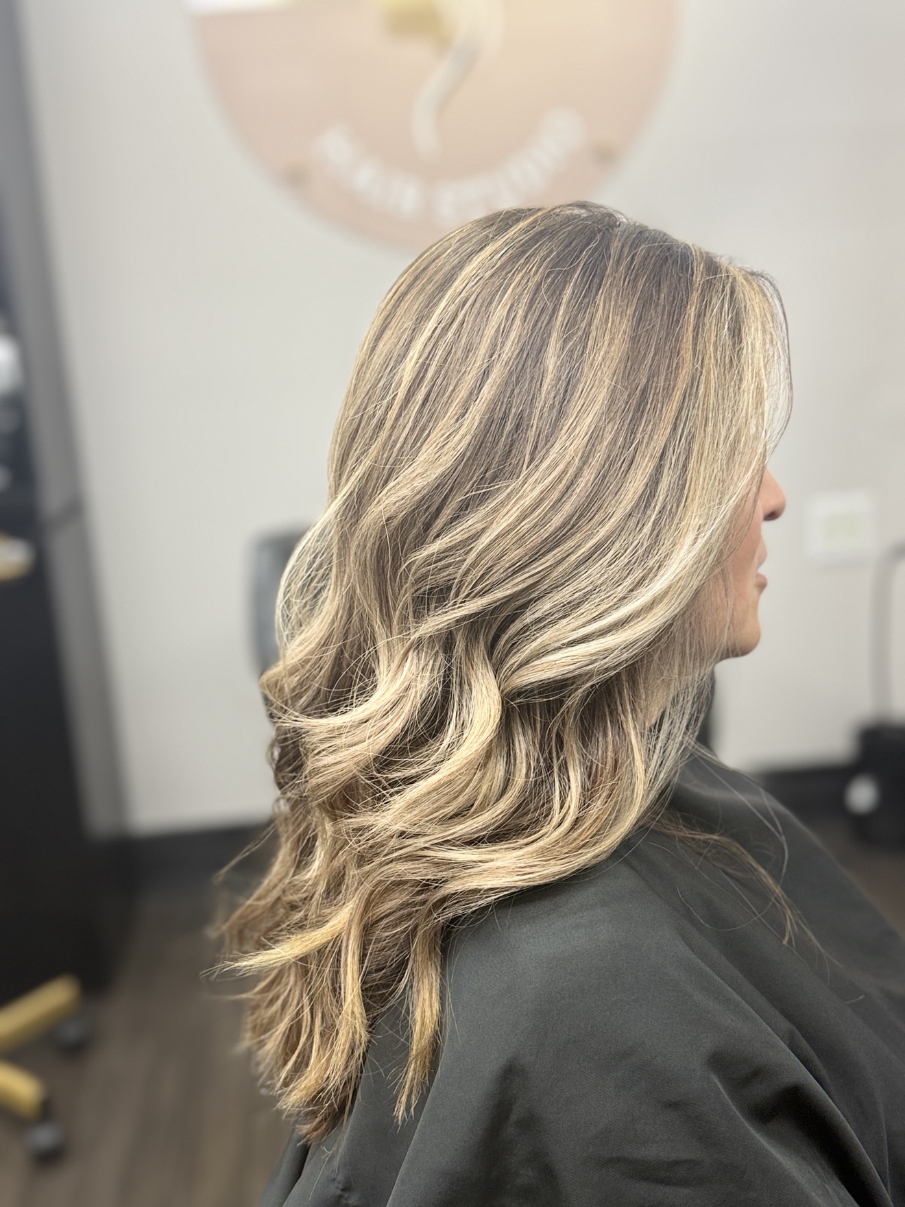 Long highlighted hair styled in glossy, soft waves at Selfie Style Hair Design
